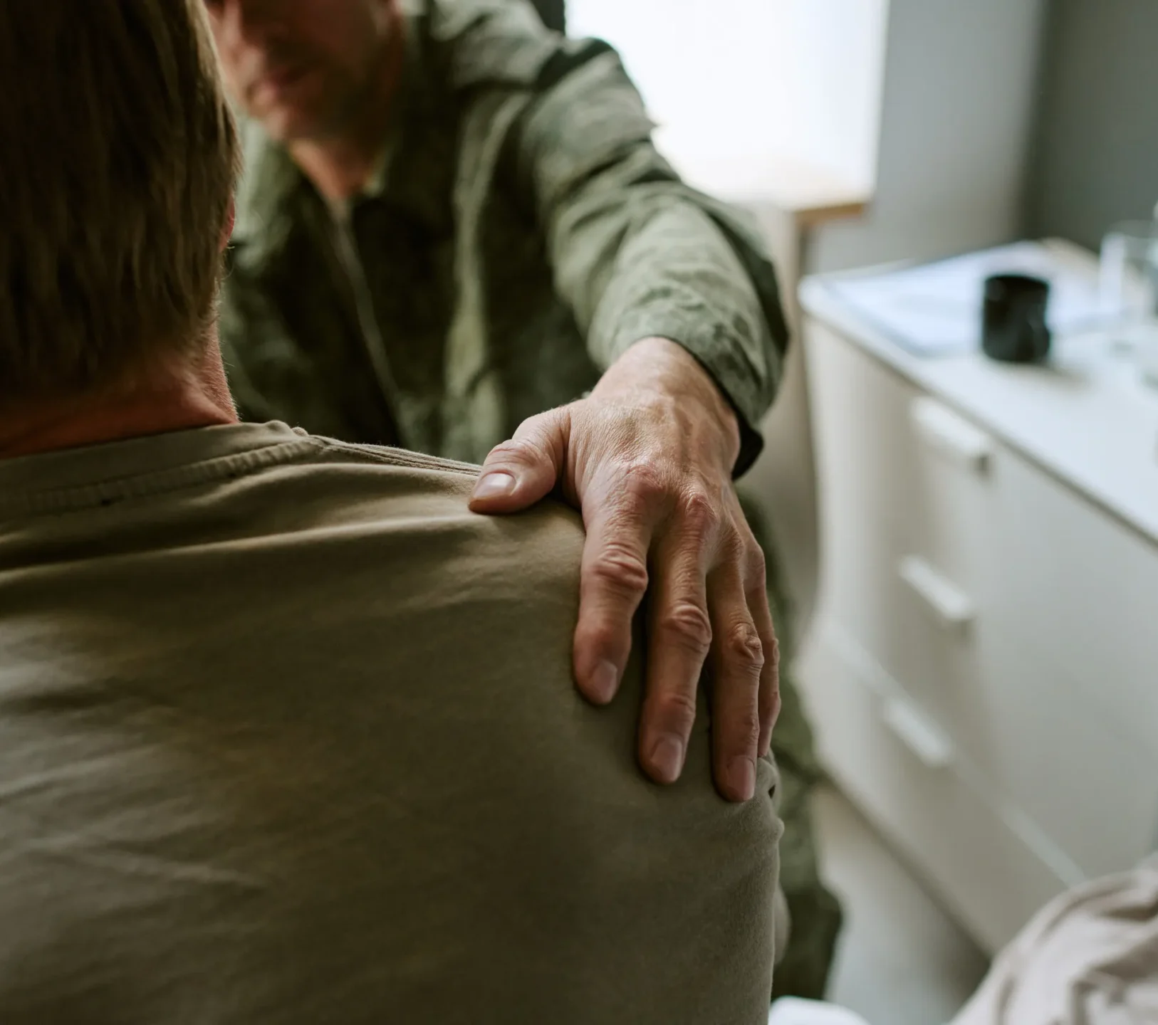 Man placing reassuring hand on a friends shoulder